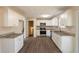 Open kitchen with white cabinets, stainless steel appliances, granite countertops, and wood-look flooring at 4547 Doral Sw Dr, Atlanta, GA 30331