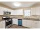 Bright kitchen featuring white cabinets, stainless steel appliances, granite counters, and wood-look flooring at 4547 Doral Sw Dr, Atlanta, GA 30331