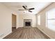 Cozy living room with a stone fireplace, wood-look floors, ceiling fan, and bright, natural light at 4547 Doral Sw Dr, Atlanta, GA 30331