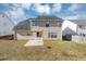 Tan house back with a patio, yard, and partial view of a wooden fence at 508 Cascade Walk, Mcdonough, GA 30253