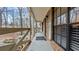 Inviting front porch with wooden railings, offering a peaceful view of the wooded area at 3870 N Shelby N Ln, Douglasville, GA 30135