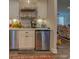 Charming basement bar with white cabinets, stainless steel appliances, and rustic flooring at 5601 Atlanta Hwy, Rutledge, GA 30663