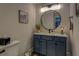 Modern bathroom with blue vanity, round mirror, and updated fixtures at 5601 Atlanta Hwy, Rutledge, GA 30663