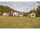 White farmhouse with detached garage and expansive lawn at 5601 Atlanta Hwy, Rutledge, GA 30663