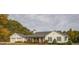 White farmhouse with black shutters, attached garage, and landscaping at 5601 Atlanta Hwy, Rutledge, GA 30663