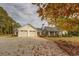 Farmhouse exterior with a three-car garage and autumn leaves at 5601 Atlanta Hwy, Rutledge, GA 30663