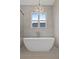 Relaxing bathroom with freestanding tub, chandelier, and large window at 2910 Caney Parc Way, Cumming, GA 30041