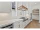 Modern kitchen with white cabinets, stainless steel appliances, and a wood range hood at 2910 Caney Parc Way, Cumming, GA 30041