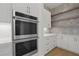 Modern kitchen with white cabinets, stainless steel appliances, and open shelving at 2910 Caney Parc Way, Cumming, GA 30041