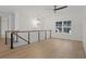 Spacious loft area with hardwood floors, large window, and modern light fixture at 2910 Caney Parc Way, Cumming, GA 30041