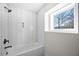 Modern tub and shower feature white herringbone tile and a window view at 1412 Dallas Sw Cir, Marietta, GA 30064