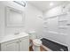 Well-lit bathroom featuring a modern shower, a dark-tiled shower base, and a stylish vanity with sink at 1626 Rice Rd, Lithonia, GA 30058