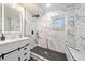 Modern bathroom featuring marble tile, a rainfall shower head, and a stylish vanity with elegant fixtures at 1626 Rice Rd, Lithonia, GA 30058