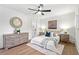 Charming bedroom features a neutral palette, wood floors, decorative mirror, and bright, airy feel at 1626 Rice Rd, Lithonia, GA 30058