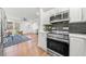 Gourmet kitchen with stainless steel appliances, white cabinetry, and stylish backsplash that opens to the living area at 1626 Rice Rd, Lithonia, GA 30058