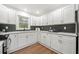 Modern kitchen with white cabinets, stainless steel appliances, and stylish black hexagon tile backsplash at 1626 Rice Rd, Lithonia, GA 30058