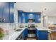 L-shaped kitchen with blue cabinets, white quartz countertops, and stainless steel appliances at 1682 Valencia Rd, Decatur, GA 30032