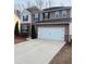 Two-story home with brown siding, a two-car garage, and well-maintained landscaping at 1963 White Top Rd., Lawrenceville, GA 30045