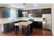 Bright kitchen featuring granite countertops, dark cabinetry, stainless appliances, and hardwood flooring at 1963 White Top Rd. Se, Lawrenceville, GA 30045