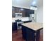 Kitchen with granite countertops, dark cabinetry, stainless appliances, and hardwood flooring at 1963 White Top Rd. Se, Lawrenceville, GA 30045