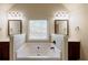 Bathroom featuring a large soaking tub with dark wood cabinets and dual vanity sinks at 3535 Clarecastle Dr, Buford, GA 30519