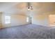 A spacious bedroom features high ceilings, carpeted floors, ceiling fan and a large window at 3535 Clarecastle Dr, Buford, GA 30519