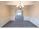Empty dining room with gray carpet and white wainscoting and access to another room at 3535 Clarecastle Dr, Buford, GA 30519