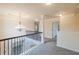 Upstairs hallway with chandelier, carpeted floor and wrought iron banister at 3535 Clarecastle Dr, Buford, GA 30519
