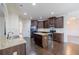 Open kitchen with island, stainless appliances, dark cabinets, and hardwood floors at 3535 Clarecastle Dr, Buford, GA 30519