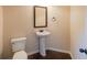 Cozy powder room featuring hardwood floors, pedestal sink, and decorative mirror at 3535 Clarecastle Dr, Buford, GA 30519