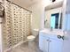 Clean bathroom with white vanity, geometric shower curtain, and tile flooring at 3877 Oakman Pl, Fairburn, GA 30213