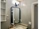 Bathroom with granite countertop, black mirror, and floating shelves at 3877 Oakman Pl, Fairburn, GA 30213