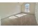 Large bedroom with neutral carpet, an arched window, and ample natural light at 3877 Oakman Pl, Fairburn, GA 30213