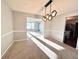 Spacious dining area with neutral walls, carpeting, and a stylish light fixture at 3877 Oakman Pl, Fairburn, GA 30213