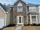 House exterior featuring stone veneer and landscaping at 3877 Oakman Pl, Fairburn, GA 30213