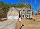 Two-story house with stone and siding accents, two-car garage, and a landscaped yard at 3877 Oakman Pl, Fairburn, GA 30213