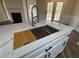 Quartz countertop kitchen island with farmhouse sink and cutting board at 11868 Fairway Overlook, Fayetteville, GA 30215