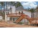 Rear exterior view featuring a wooden deck, stairs, white siding, and ample outdoor space at 93 Highway 81, Oxford, GA 30054