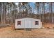 Exterior view of the storage shed with red trim around the windows in the backyard at 93 Highway 81, Oxford, GA 30054