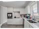 Modern kitchen with white cabinetry, stainless steel appliances, and a bright window overlooking the yard at 1619 Ridgeview Nw Dr, Conyers, GA 30012