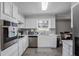 Bright kitchen features white cabinets, stainless steel appliances, and a window view of the backyard at 1619 Ridgeview Nw Dr, Conyers, GA 30012