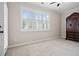 Bright bedroom featuring large window, plantation shutters, and carpeted floors at 4535 Meadow Green Ln, Acworth, GA 30101