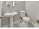 Bathroom has a pedestal sink, toilet, grey walls and ceramic tile flooring at 8270 Mossybrook Ln, Douglasville, GA 30135