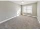 Bright bedroom featuring plush carpet and natural light from the window at 8270 Mossybrook Ln, Douglasville, GA 30135