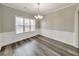Dining area with a modern chandelier, large window, and classic wall paneling at 8270 Mossybrook Ln, Douglasville, GA 30135