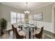 Traditional dining room showcases a glass table, modern chandelier, and paneled walls at 8270 Mossybrook Ln, Douglasville, GA 30135