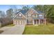 Inviting two-story home with a covered porch, stone accents, and a two-car garage at 8270 Mossybrook Ln, Douglasville, GA 30135
