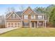 Charming two-story home with a two-car garage and well-manicured front lawn at 8270 Mossybrook Ln, Douglasville, GA 30135
