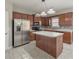 Well-lit kitchen features stainless steel appliances, tile backsplash, island, and ample counter space at 8270 Mossybrook Ln, Douglasville, GA 30135