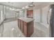 Kitchen island with wood cabinets and tile floor overlooking great room with fireplace and staircase at 8270 Mossybrook Ln, Douglasville, GA 30135